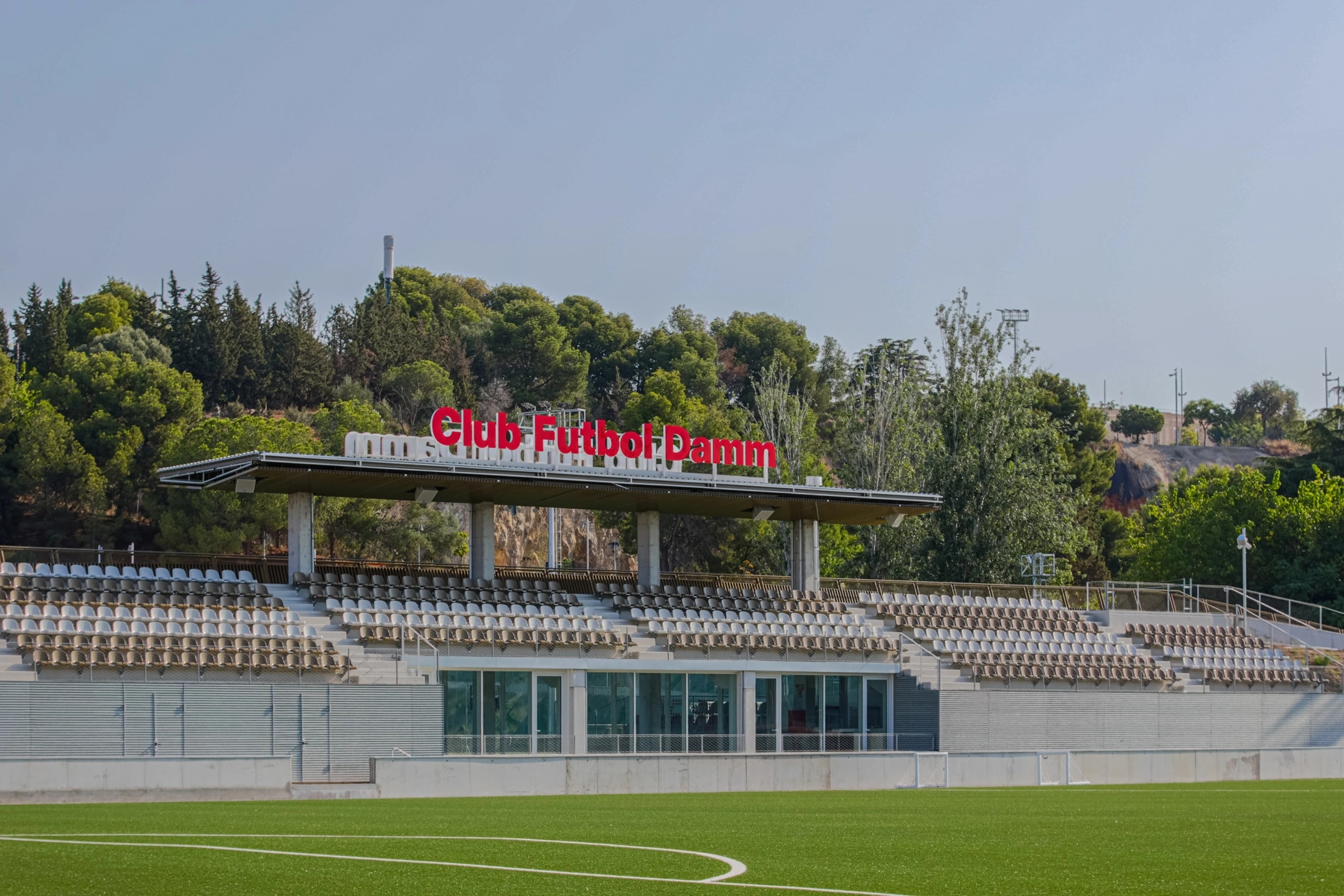 Club de futbol Damm en Montjuïc, Barcelona. Se ven las gradas y el logotipo del club.