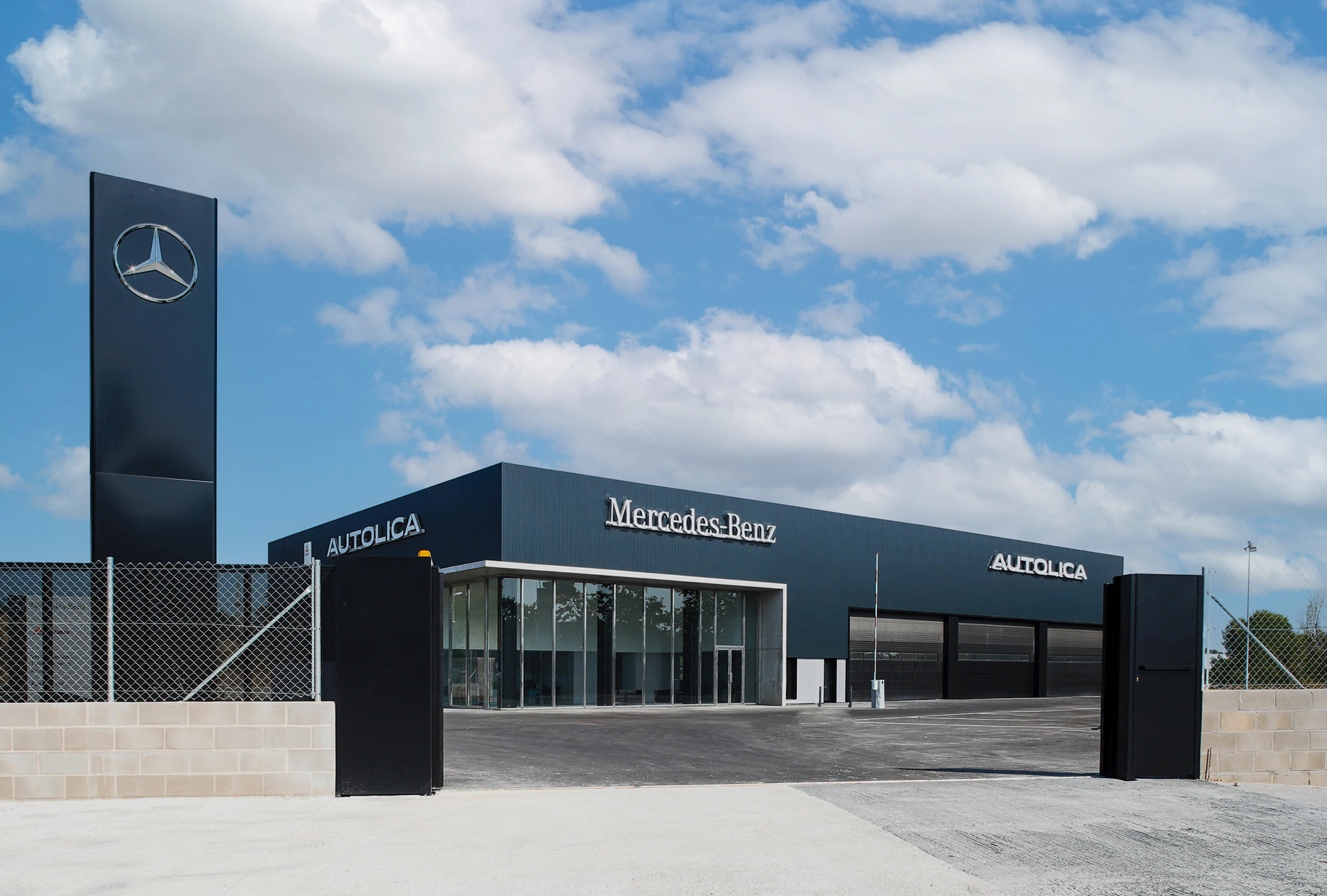 Entrada principal del concesionario Autolica Mercedes-Benz con edificio moderno y zona de acceso.