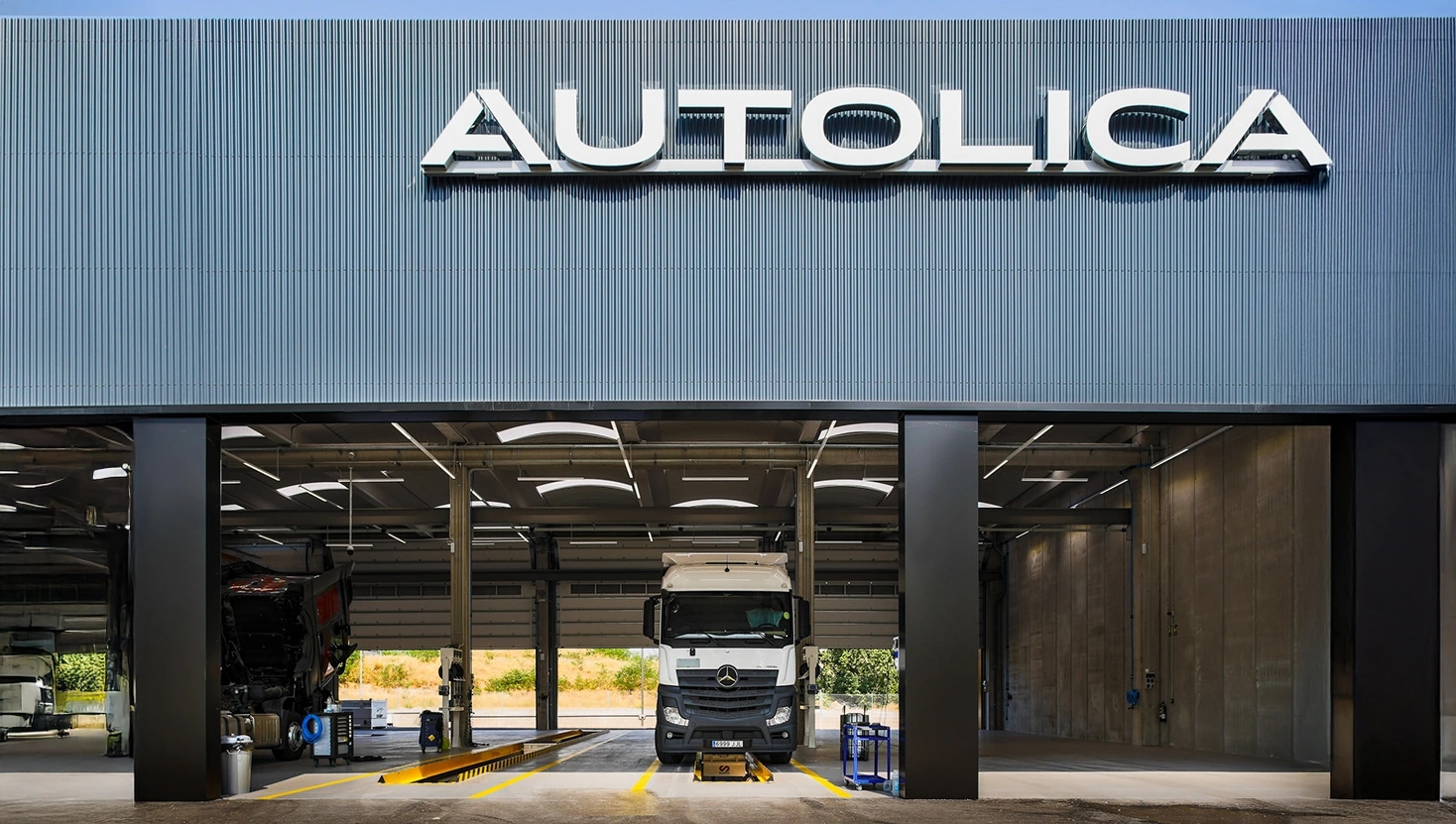 Camión Mercedes-Benz en la entrada del taller Autolica visto desde el exterior.