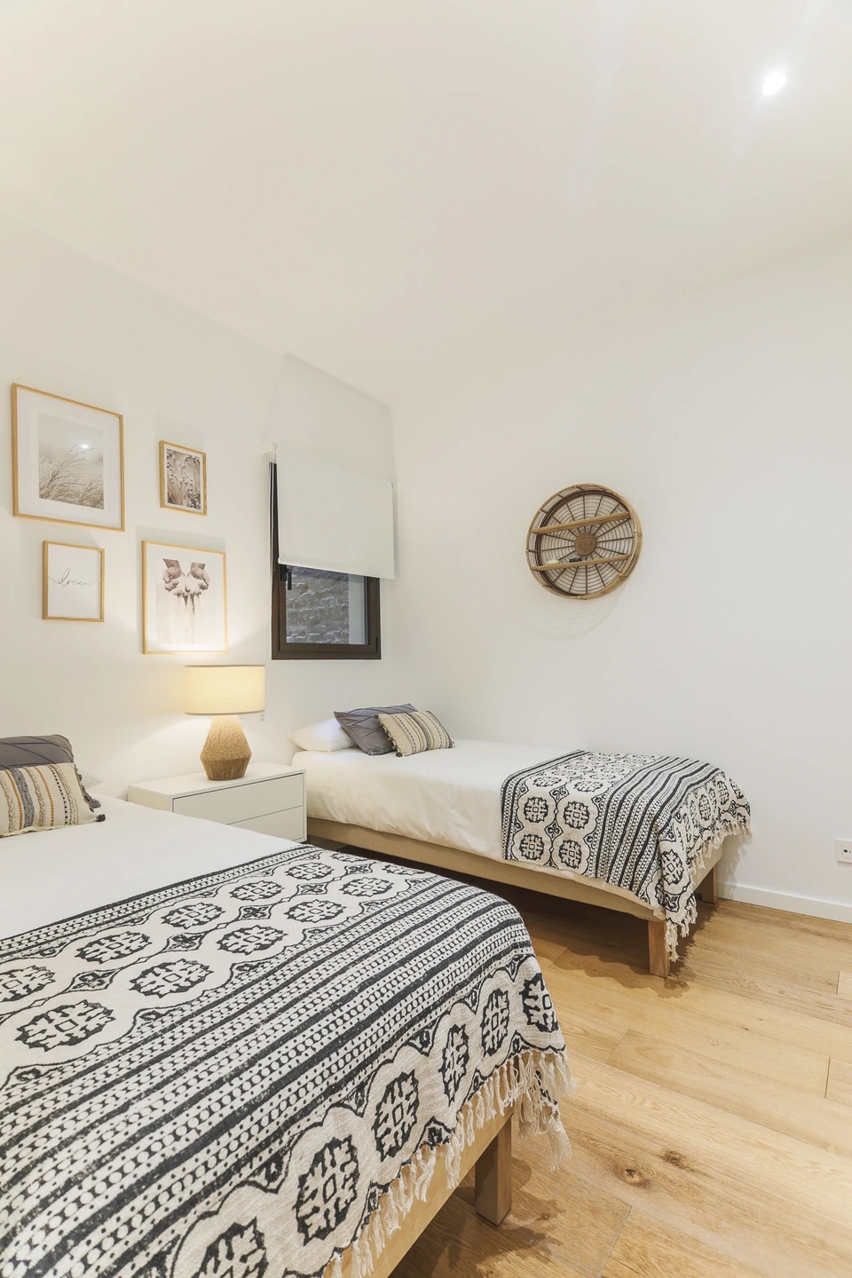 Fotografía de dormitorio con dos camas individuales, textiles en blanco y negro y decoración natural en Atelier Apartments