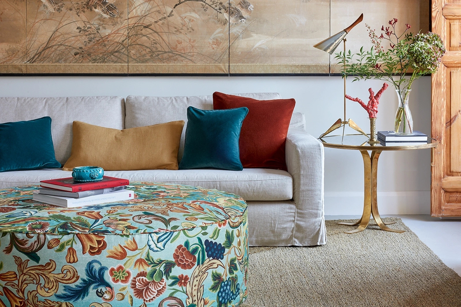 Fotografía de los tejidos de la colección Bloomsbury Collection - Güell Lamadrid y Melián Randolph. mesa con el estampado principal de la colección y sofá con los cojines de los colores principales de la colección.