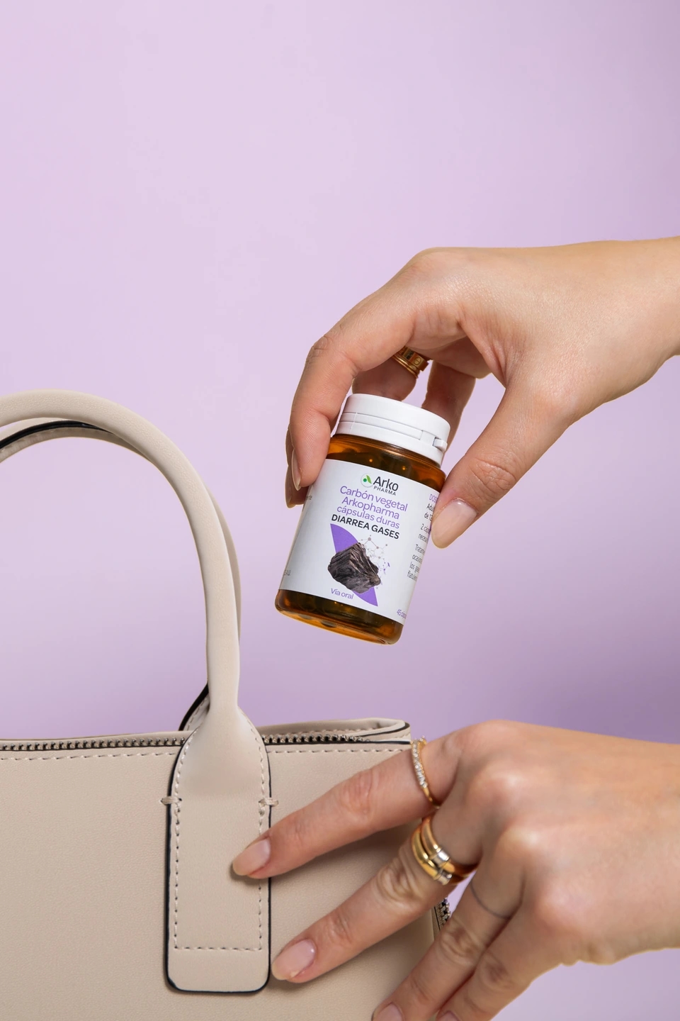 Mujer saca Arkocáspulas de carbón vegetal de su bolso, producto de la farmacéutica Arkopharma para una sesión fotográfica creativa en Madrid.