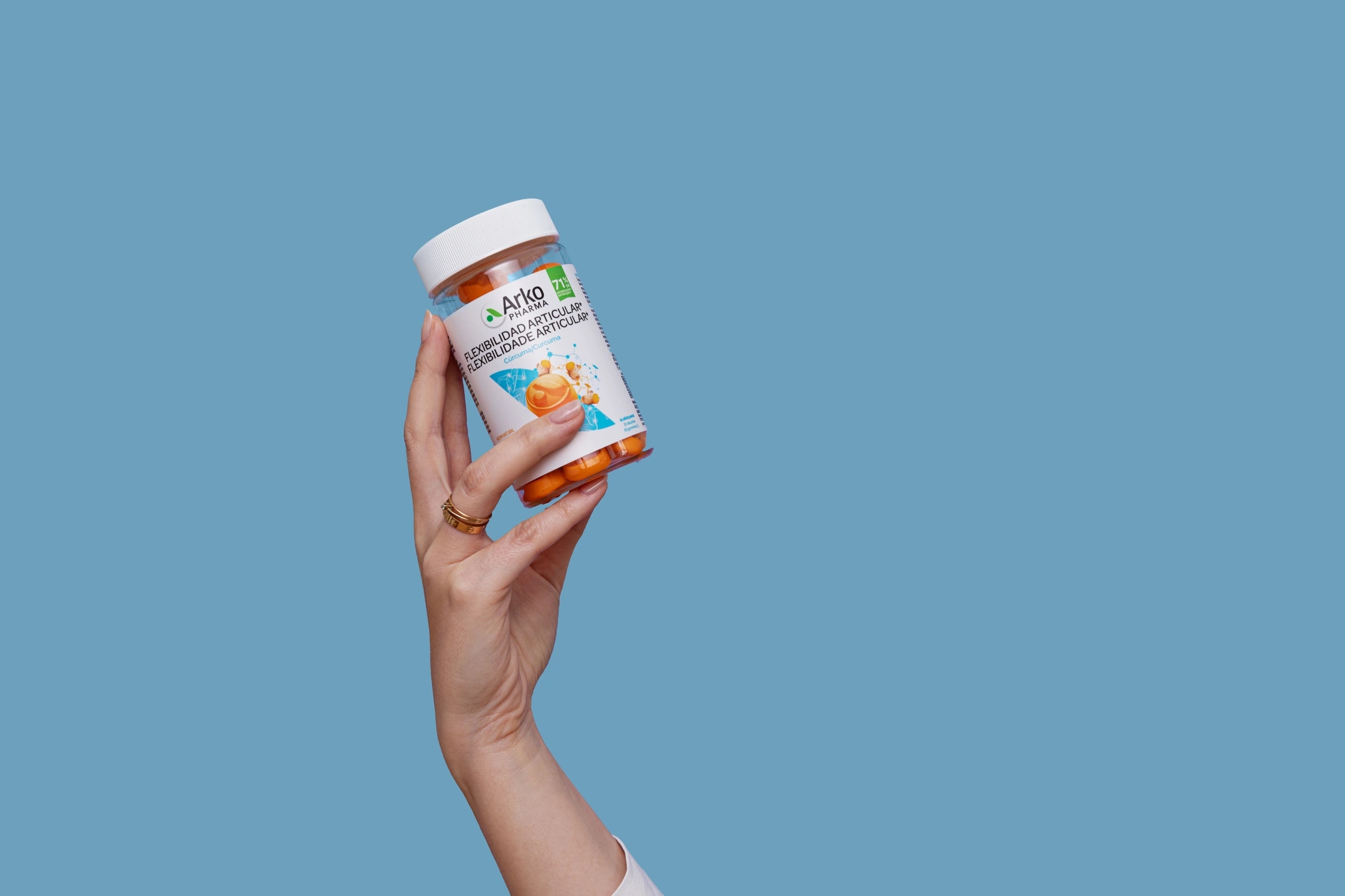 Mujer sujeta el bote de gummies de cúrcuma, producto de la farmacéutica Arkopharma para una sesión fotográfica creativa en Madrid.