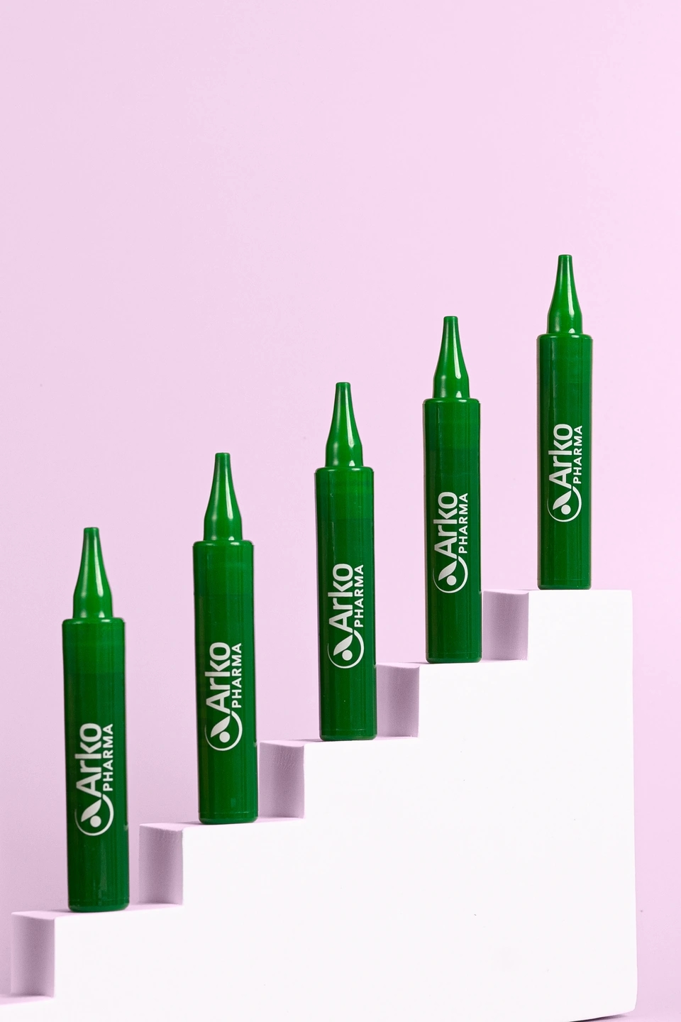 Viales de alcachofa forte en fondo rosa palo, producto de la farmacéutica Arkopharma para una sesión fotográfica creativa en Madrid.