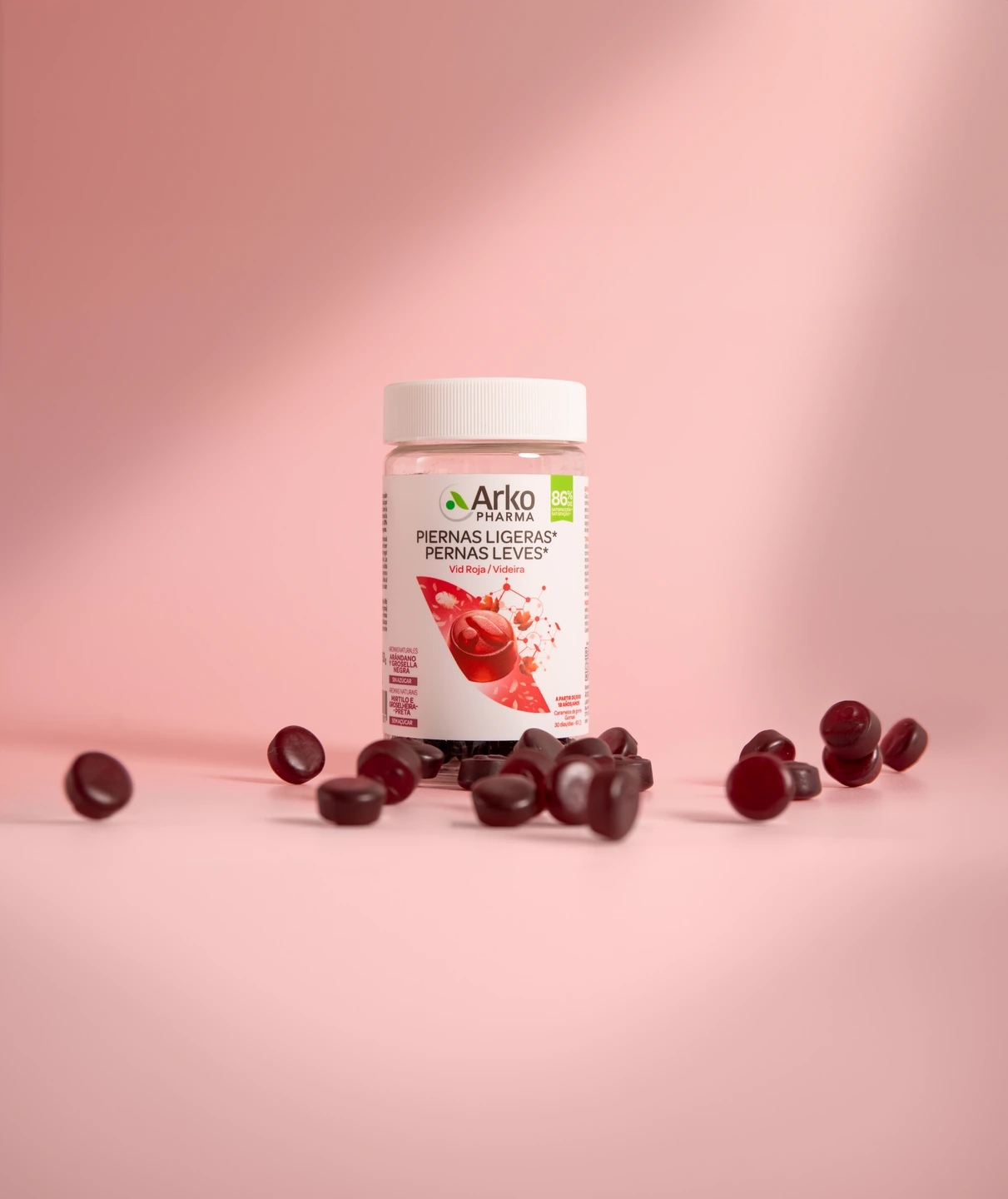Gominolas para piernas ligeras en fondo rosa, producto de la farmacéutica Arkopharma para una sesión fotográfica creativa en Madrid.