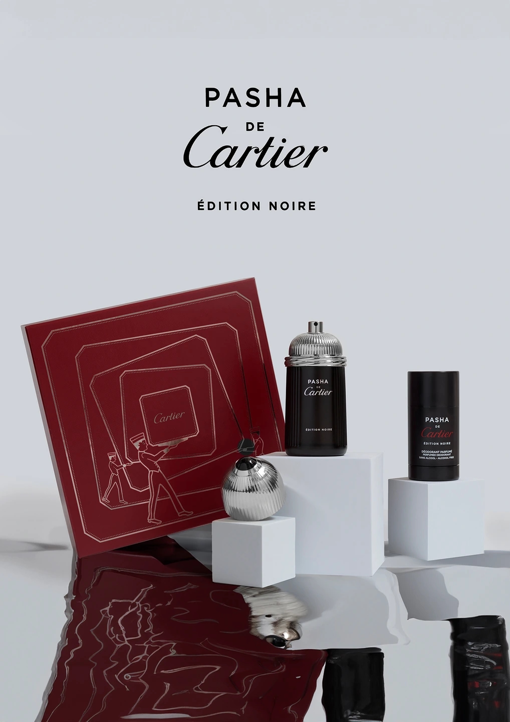 Composición clara del perfume Cartier PASHA, con el desodorante y la caja en la que viene envuelto. Fondo gris muy claro. Fotografía para la marca de perfumerías Éclair.