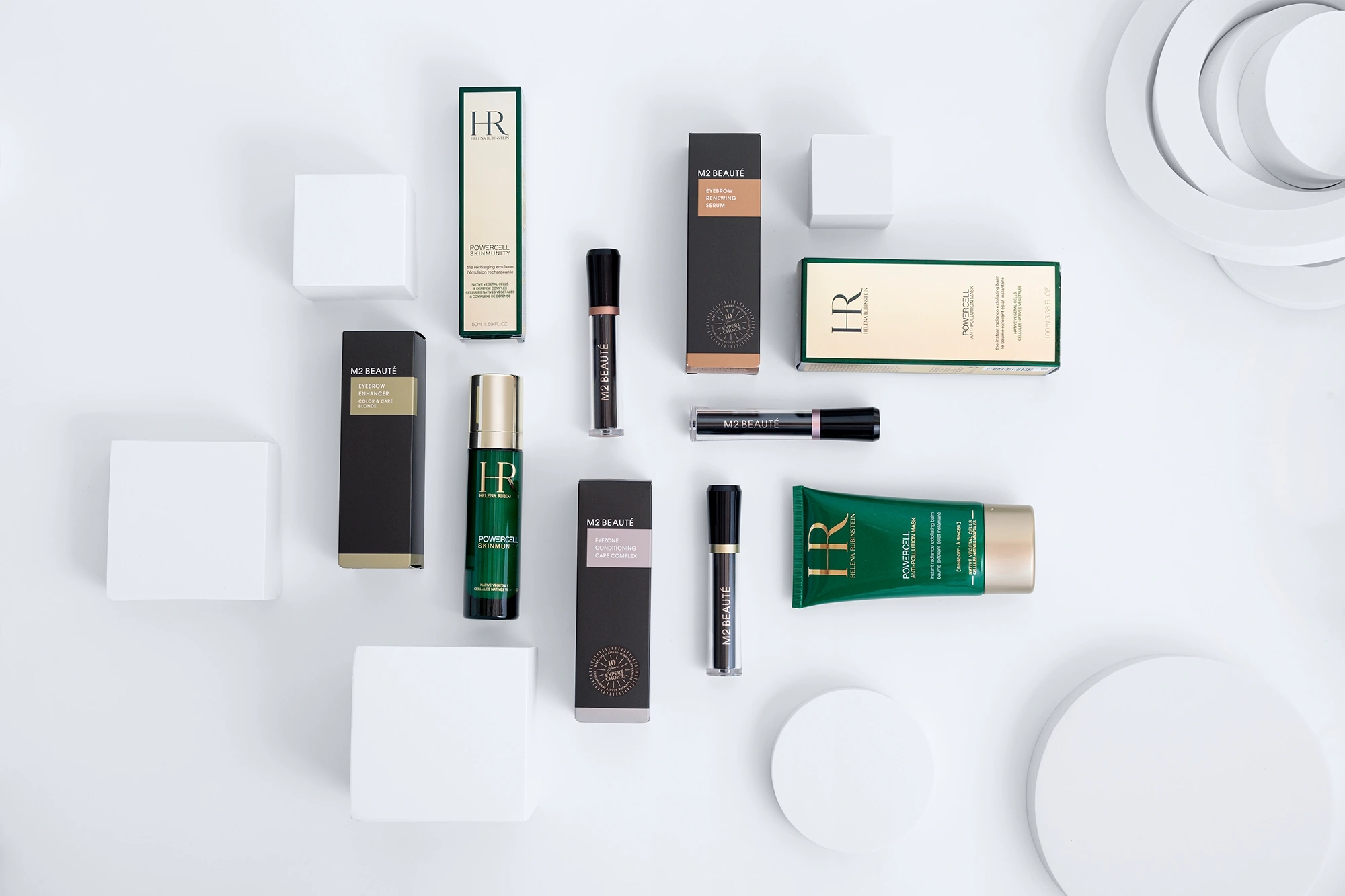 Fotografía zenital de composición con productos de M2 beauté y Helena Rubinstein en fondo blanco