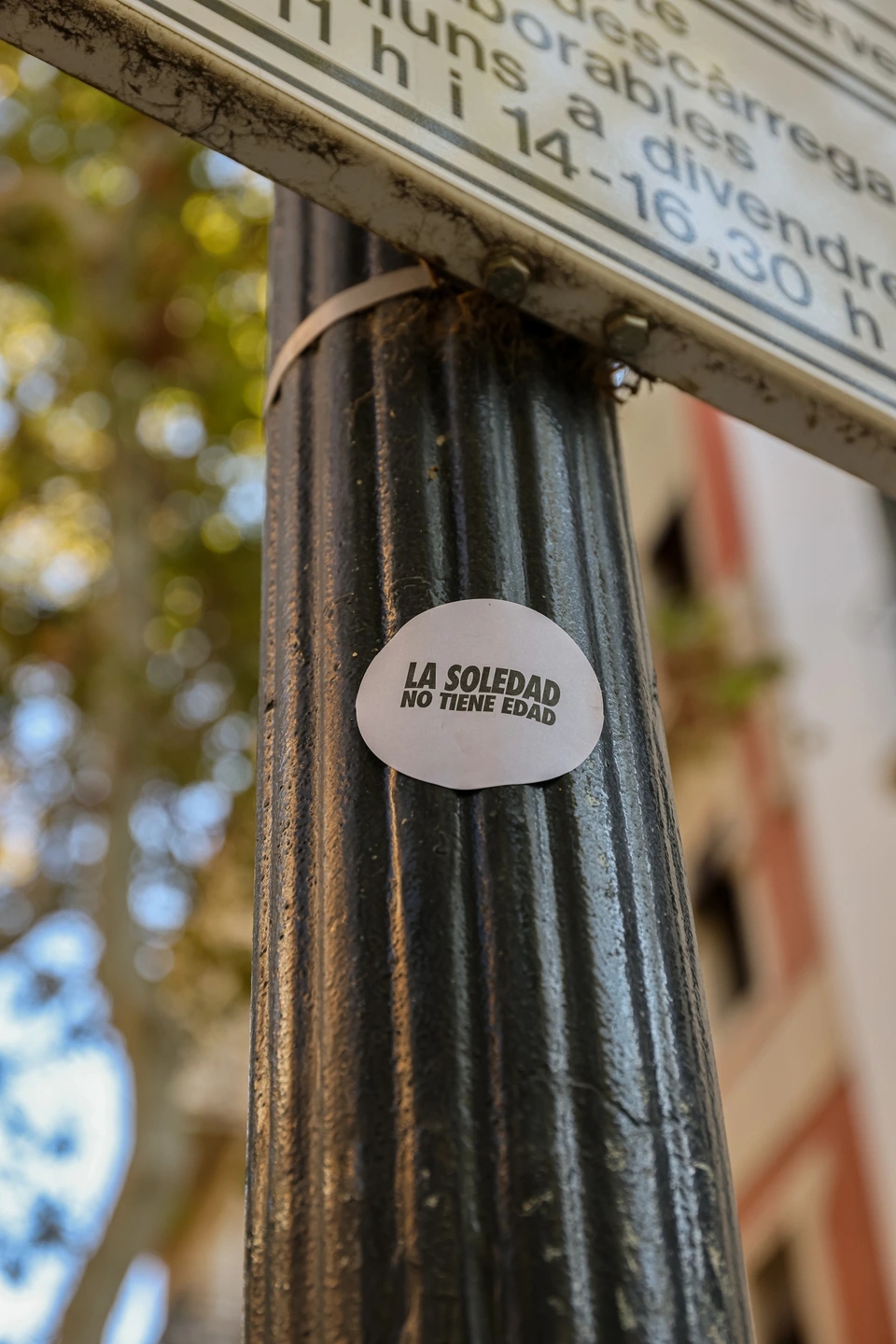 Poste con pegatina La Soledad no tiene edad campaña creativa para la empresa Somos Estupendas. 