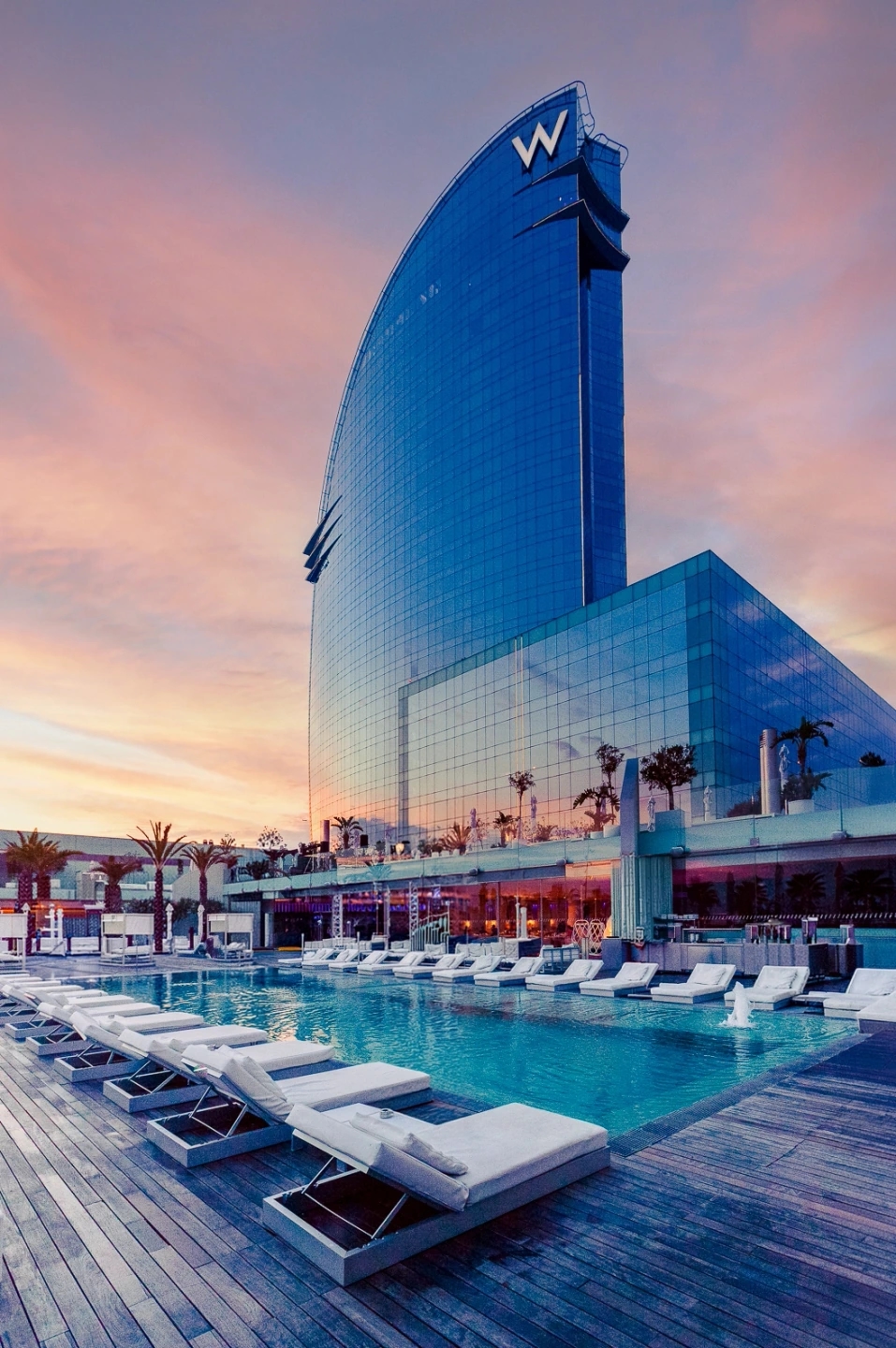 Piscina del Hotel W Barcelona (W Vela) junto al mar Mediterráneo, vista exterior del icónico edificio en forma de vela.