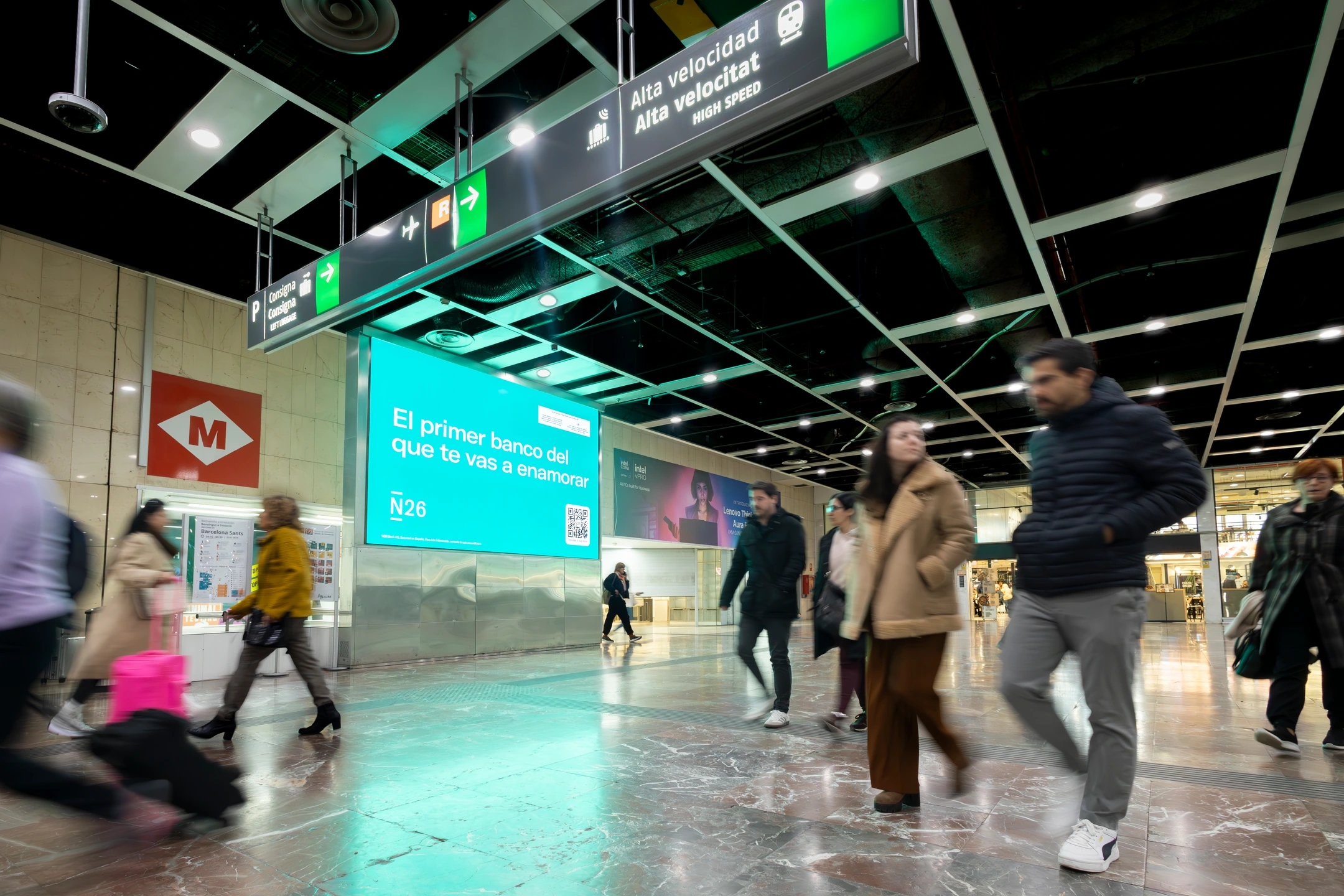 Gente pasando delante de una pantalla con la campaña del banco N26
