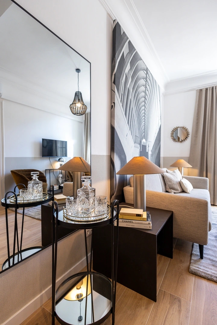 Comedor de un apartamento de Enville en Barcelona. Estilo lujoso y elegante. Espejo refleja la otra parte del comedor.