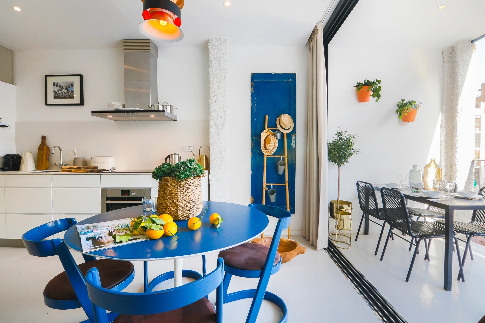 Cocina y Comedor de un apartamento de Enville en Barcelona. Estilo mediterráneo y elegante. Ventanal amplio que da acceso a la terraza