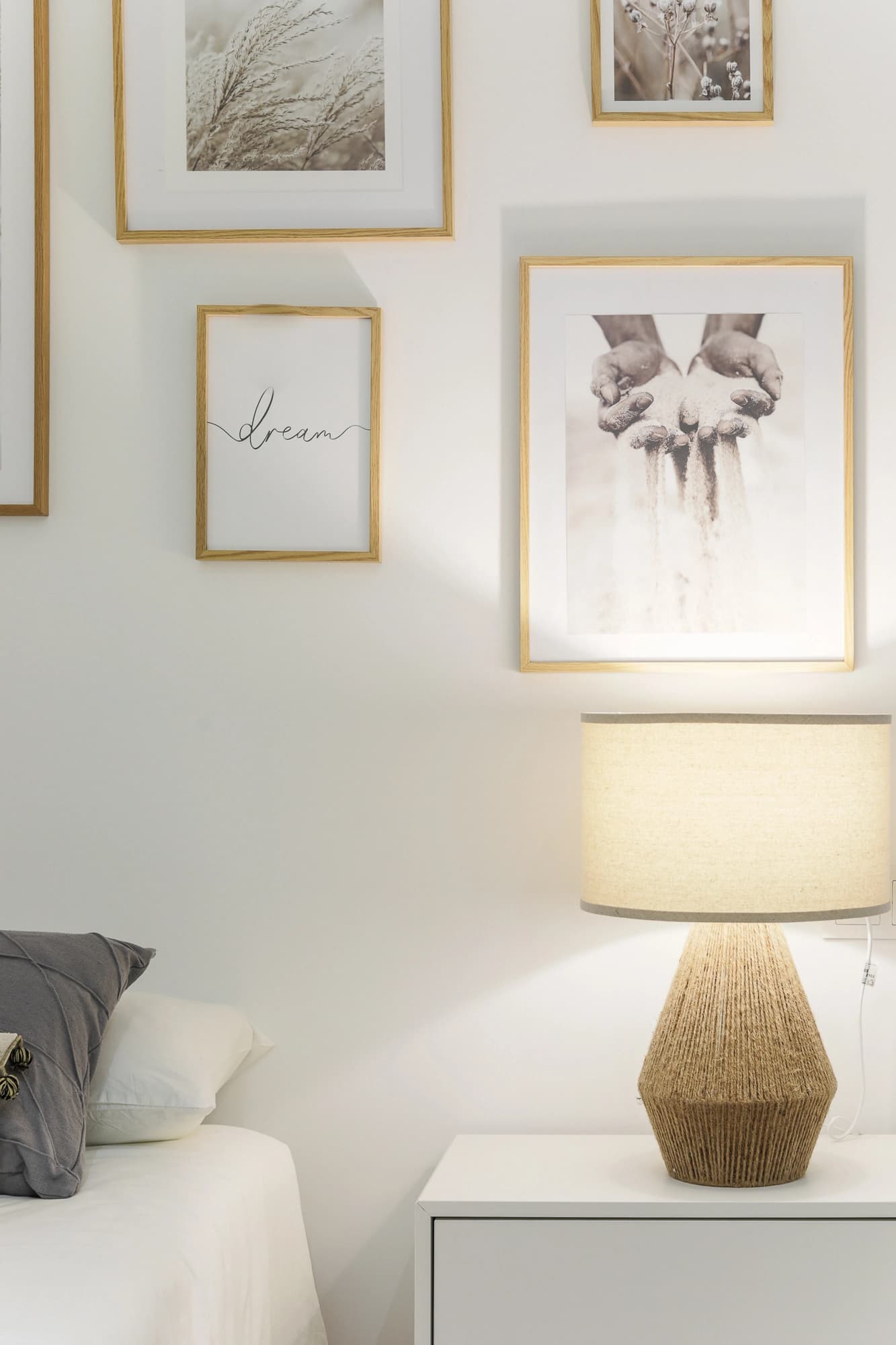 Fotografía de detalle de lámpara de mesa y composición de cuadros decorativos en un dormitorio de Atelier Apartments.