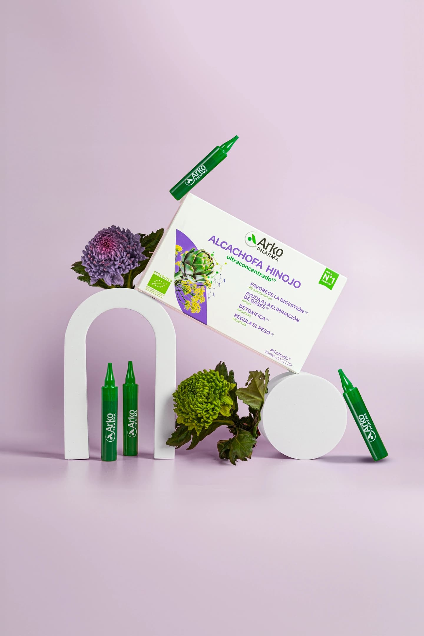 Viales y caja de Alcachoa e Hinojo en presentación creativa con fondo violeta, producto de la farmacéutica Arkopharma para una sesión fotográfica creativa en Madrid.