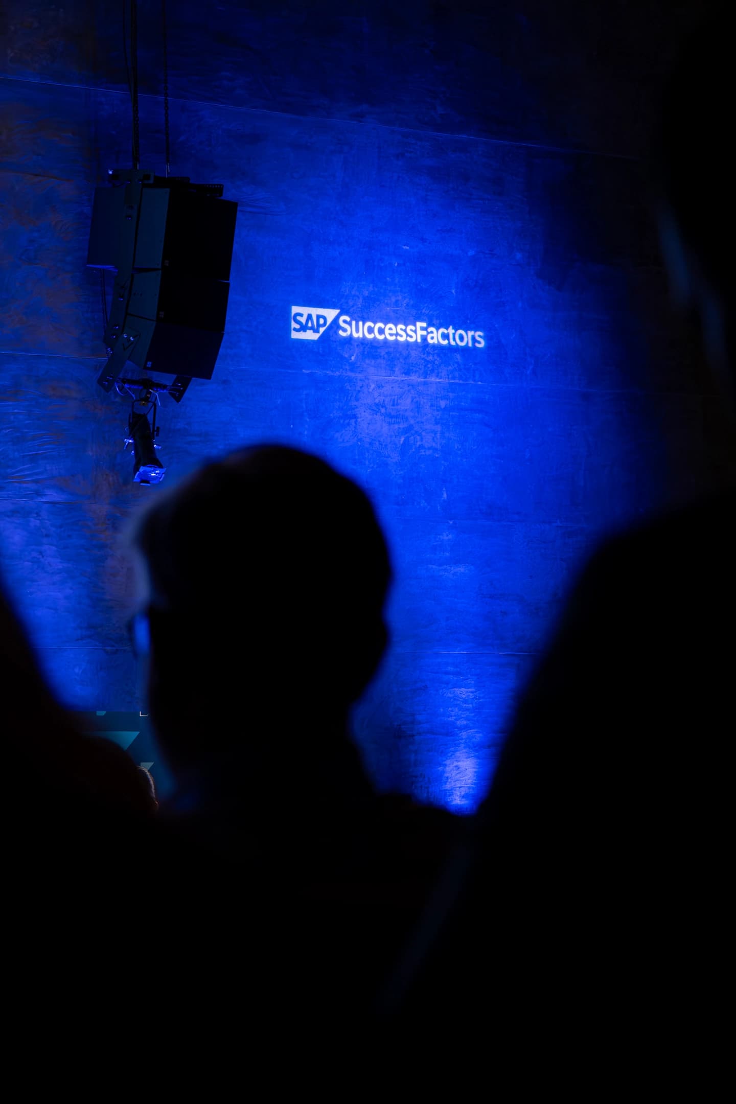 Logotipo proyectado en el escenario con cabezas a contraluz en el evento SAP Partner summit Barcelona 2025 en La illa Diagonal.