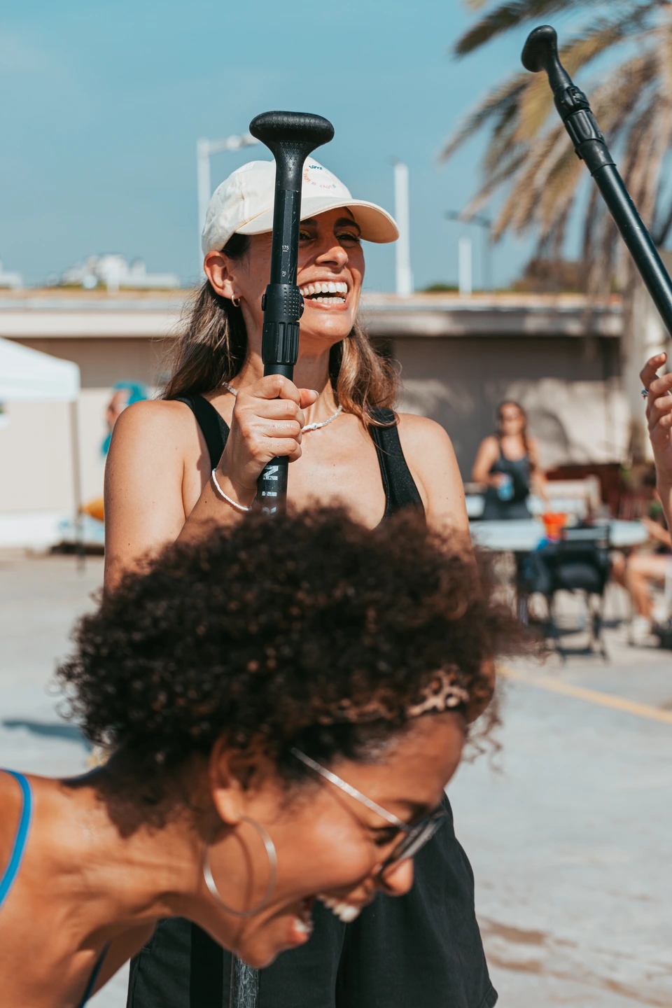 Mujeres riendo en la playa. Actividad durante el evento de la Regatta Iomramh, regata irlandesa anual de St. Patrick’s Day en el puerto de Barcelona.