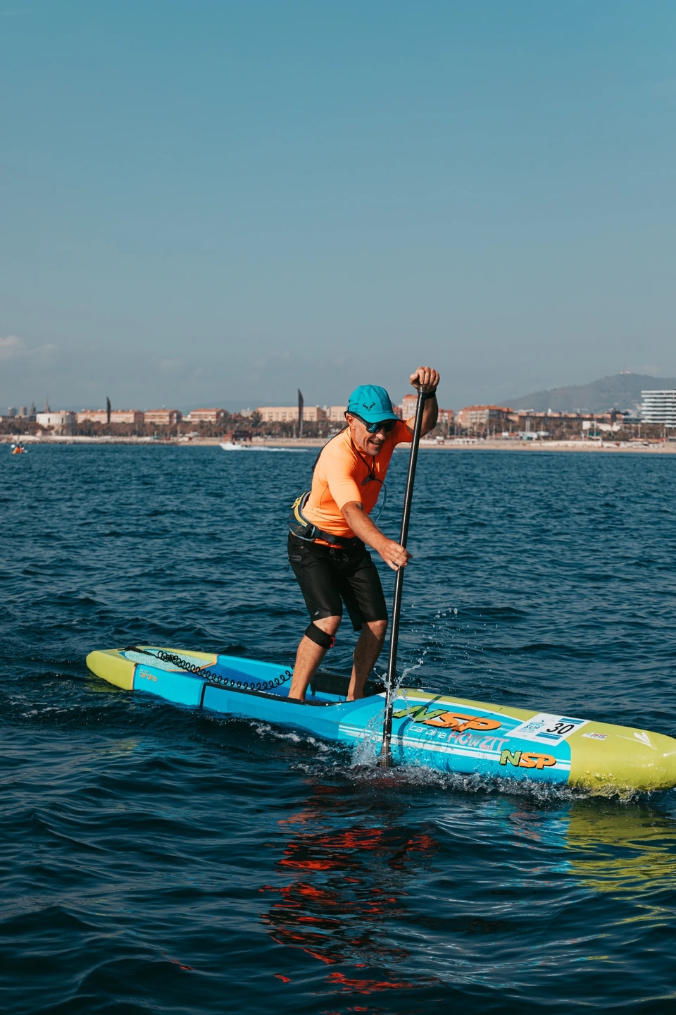 Paddle surf remando durante la carrera. Reportaje fotográfico de la Regatta Iomramh, regata irlandesa anual de St. Patrick’s Day en el puerto de Barcelona.
