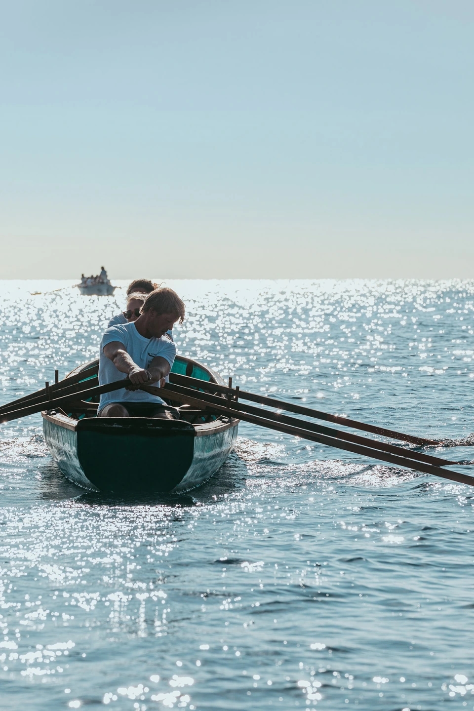 Fotografía de un currach y su equipo en el mar. Reportaje fotográfico de la Regatta Iomramh, regata irlandesa anual de St. Patrick’s Day en el puerto de Barcelona.