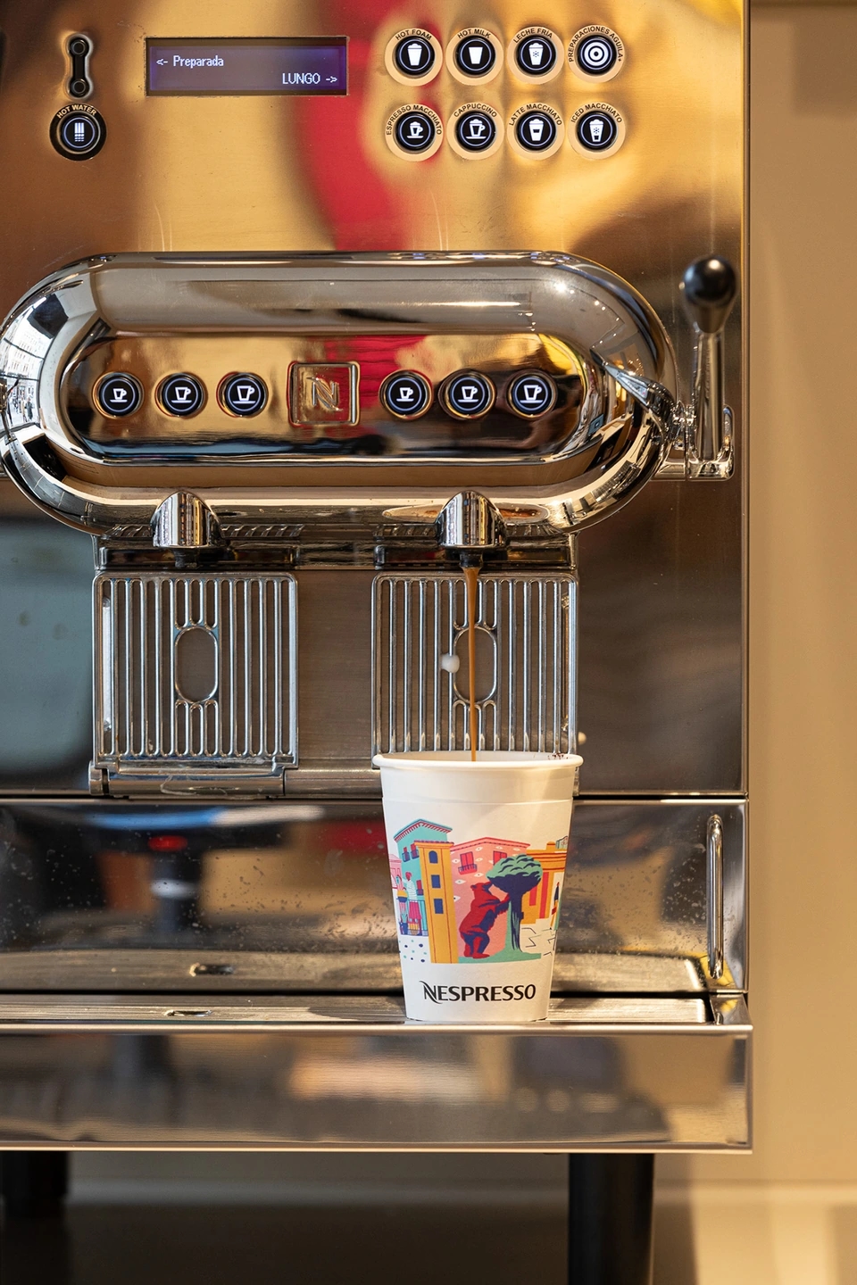 Máquina de café profesional plateada haciendo un café en la tienda Nespresso gran vía de Madrid