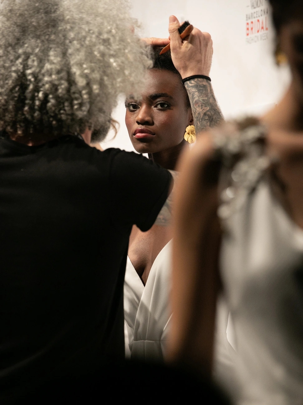 Modelo de piel oscura siendo peinada por el equipo de l'Óreal para el desfile de Beba's en la Barcelona Bridal Fashion Week.