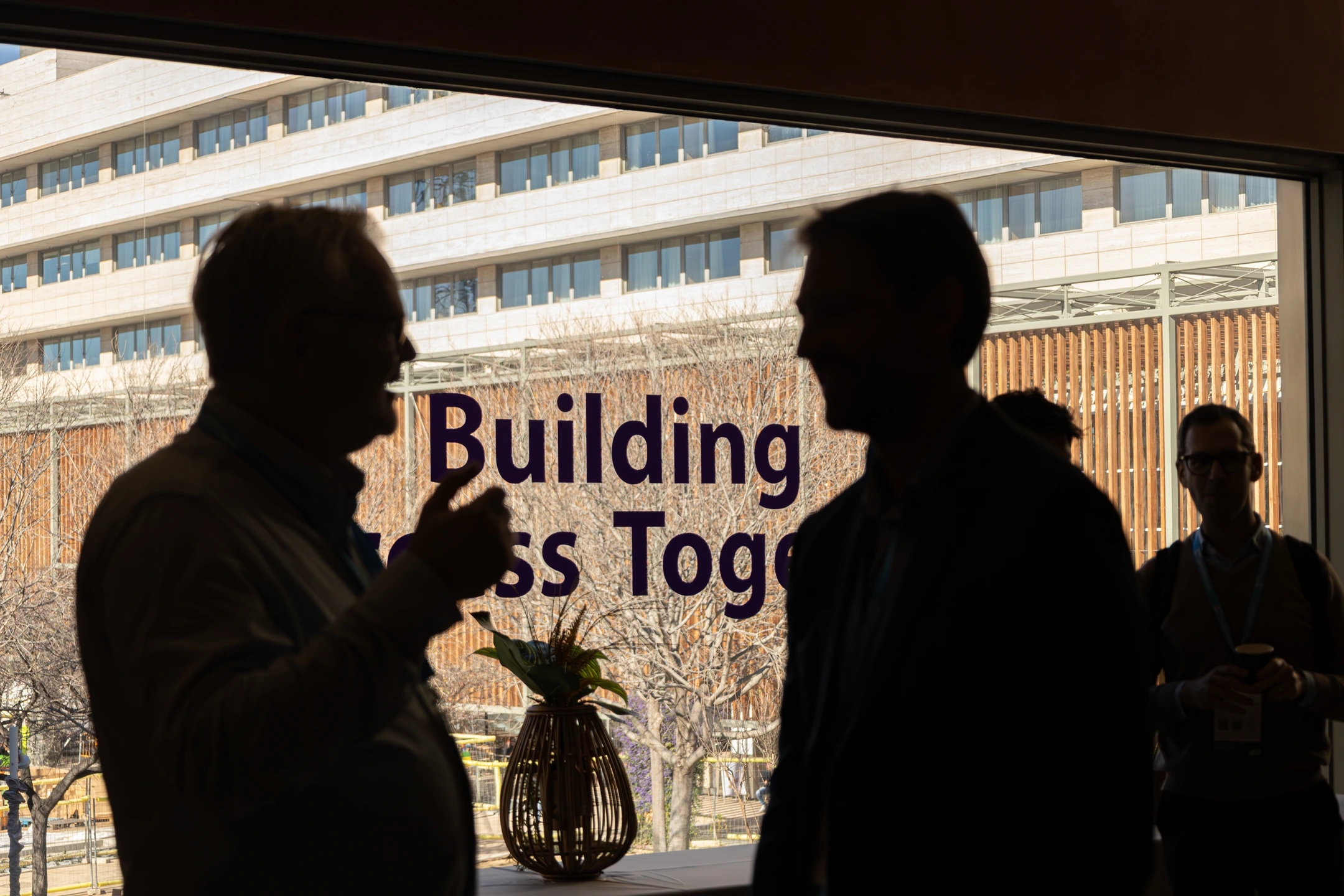 Equipo a contraluz con la frase "Building business together" en el evento SAP Partner summit Barcelona 2025 en La illa Diagonal.