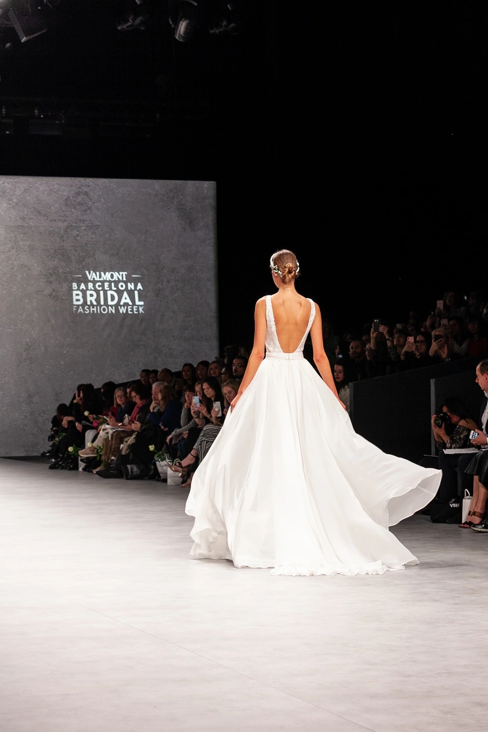 Modelo con vestido de novia de espaldas en ell desfile de Cristina Tamborero para la Barcelona Bridal Fashion Week.