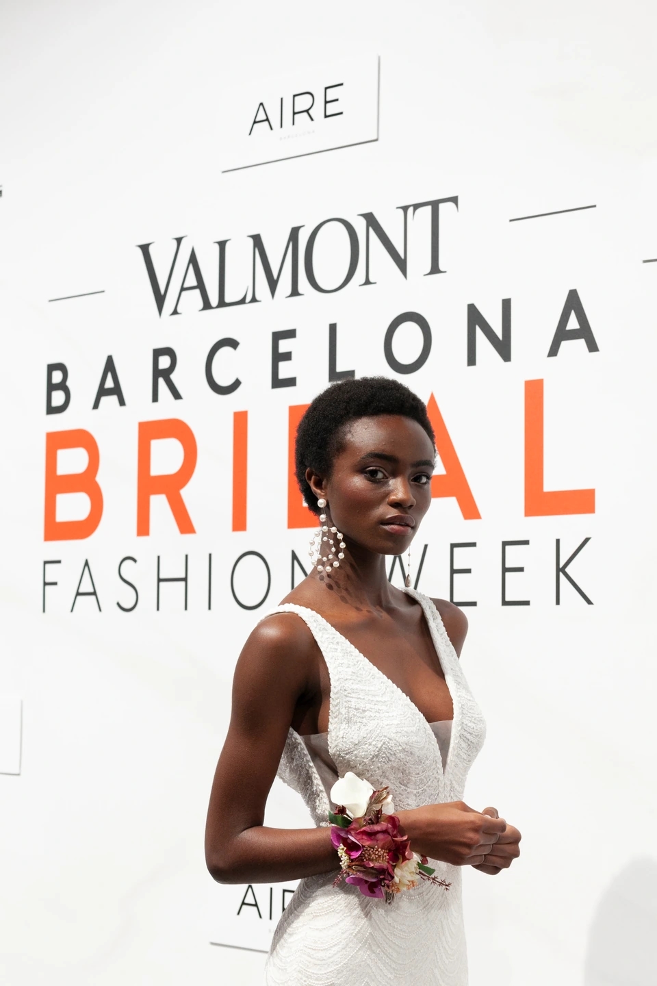 Modelo posando con su vestido de novia delante del cartel de Valmont Barcelona Bridal Fashion Week.