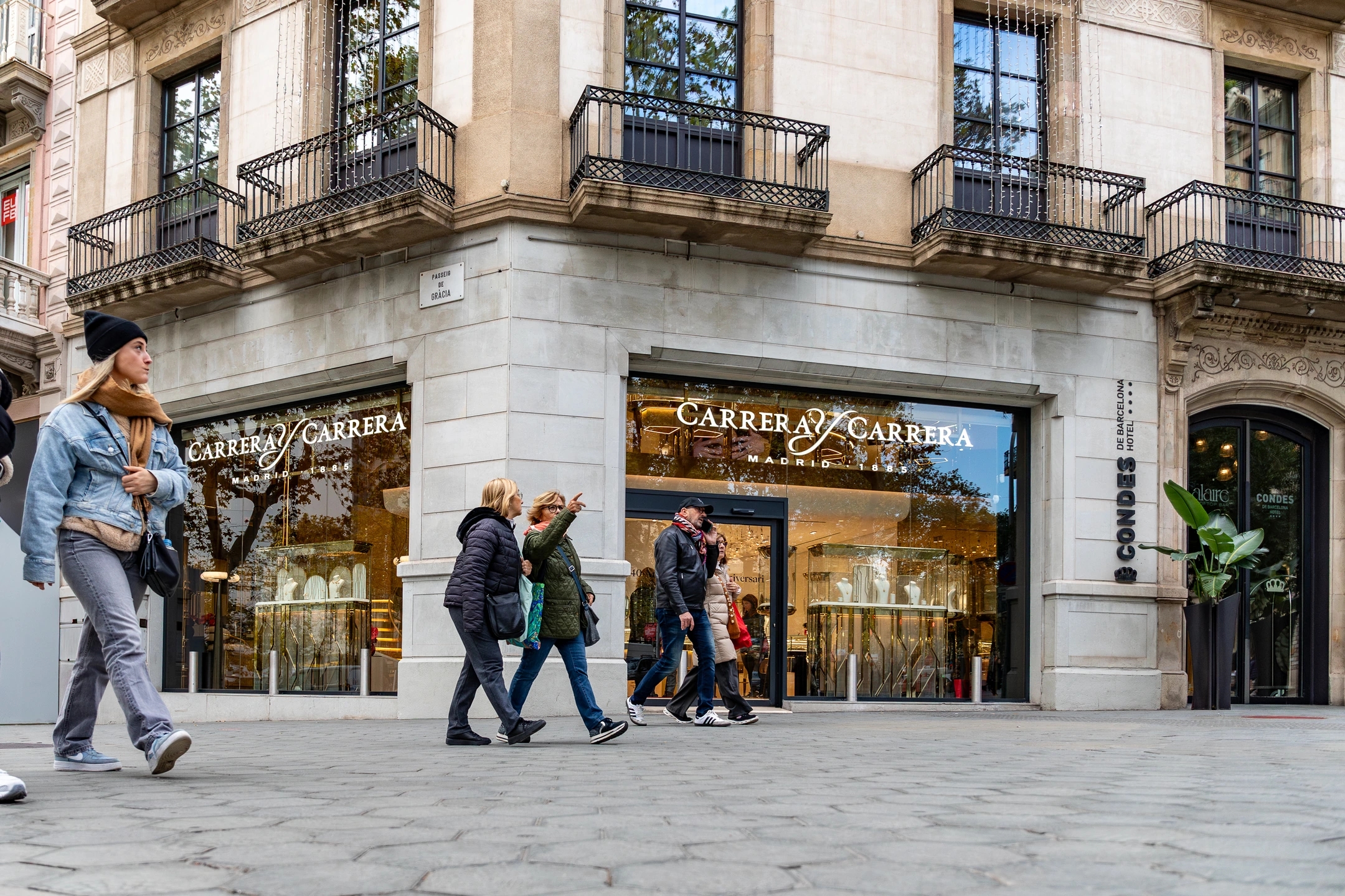 Calle de paseo de gracia donde se ven personas caminando delate de la joyería de carreraycarrera
