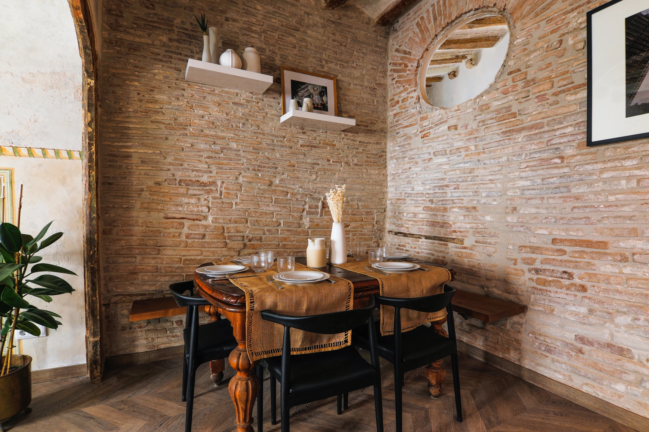 Enville Apartments carrer del Carme. Mesa con cuatro sillas en una habitación de tocho antiguo. Mezcla de estilo clásico y moderno.