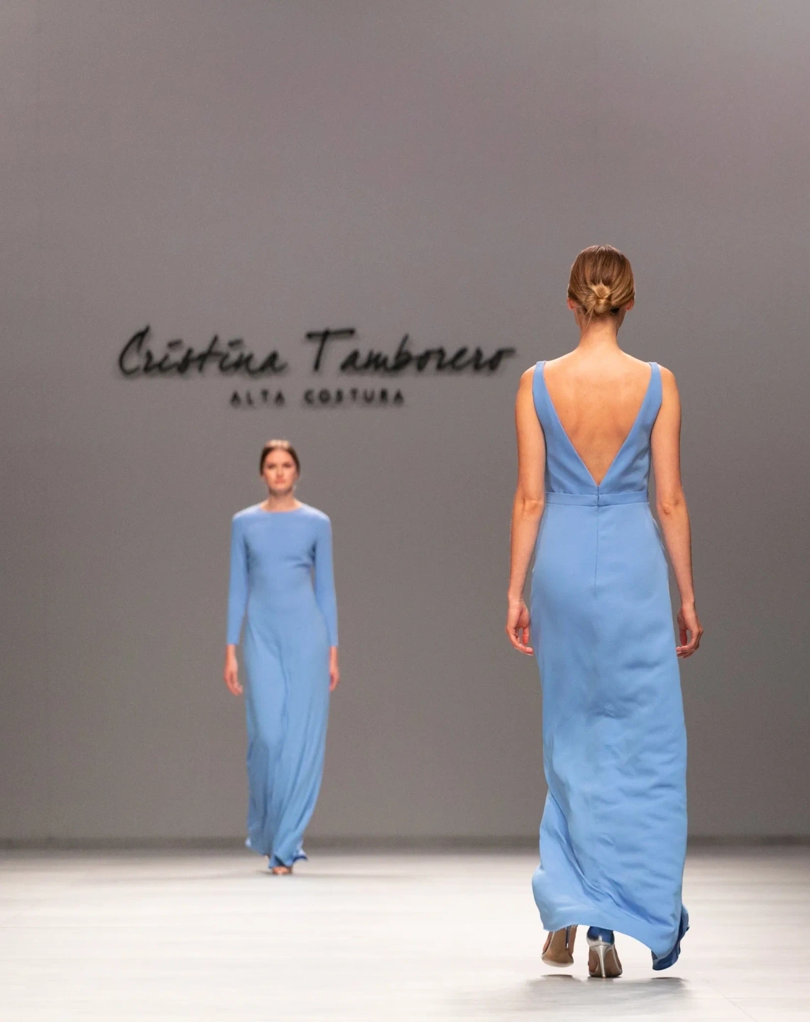 Modelos con vestidos de invitda azules cruzándose en el desfile de Cristina Tamborero para la Barcelona Bridal Fashion Week.