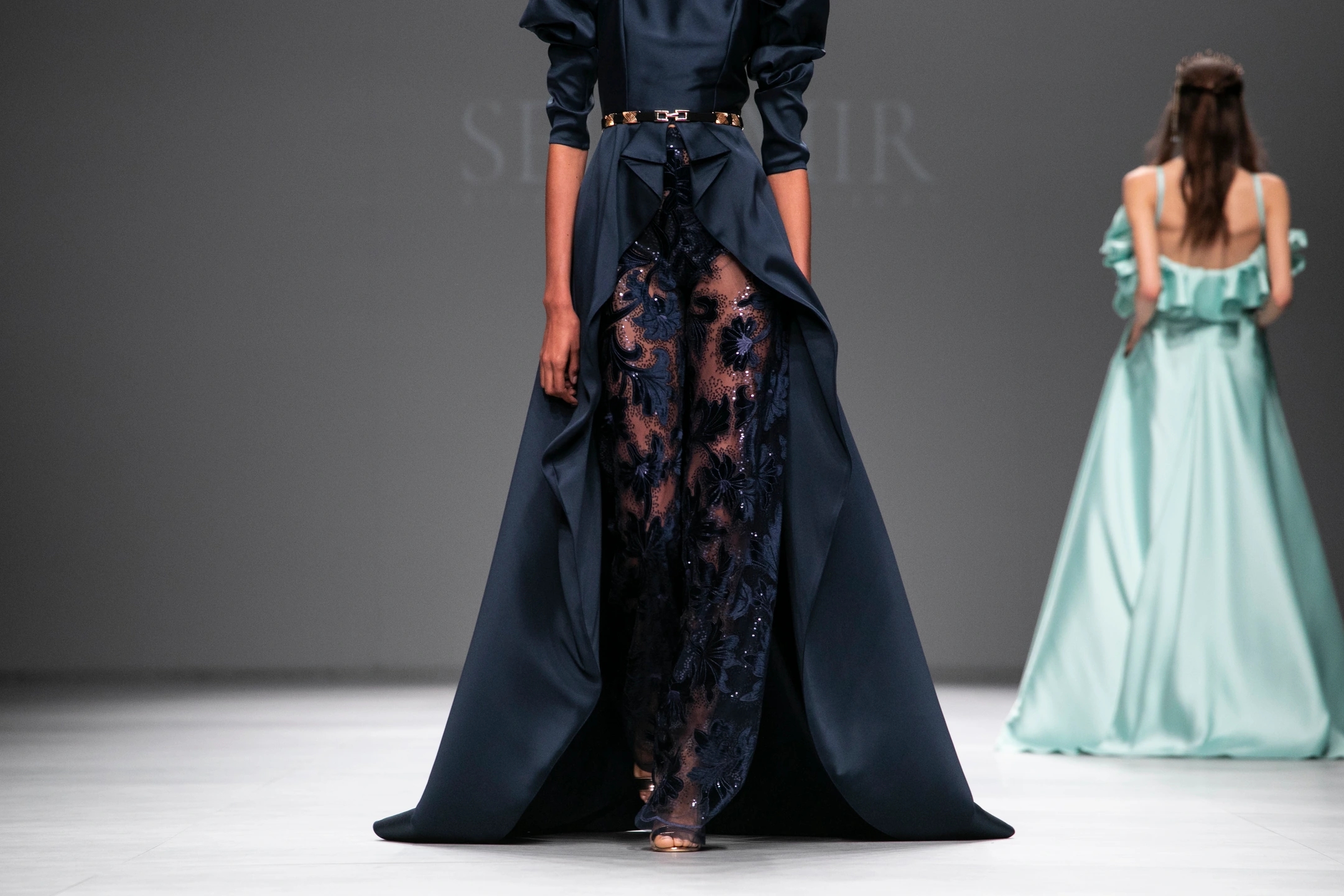 Modelo mujer andando de frente con su vestido de novia color azul ultramarino oscuro en el desfile de Sedomir Rodríguez de la Sierra para la pasarela de Barcelona Bridal Fashion Week.