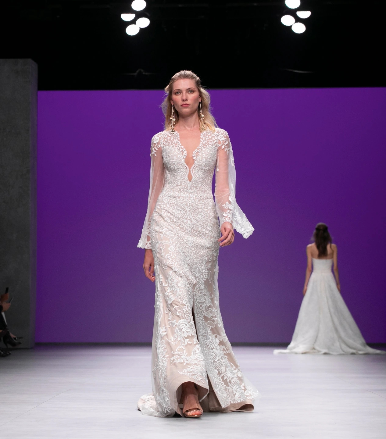 Modelo con vestido de novia andando de frente en el desfile de María Salas para la Barcelona Bridal Fashion Week.