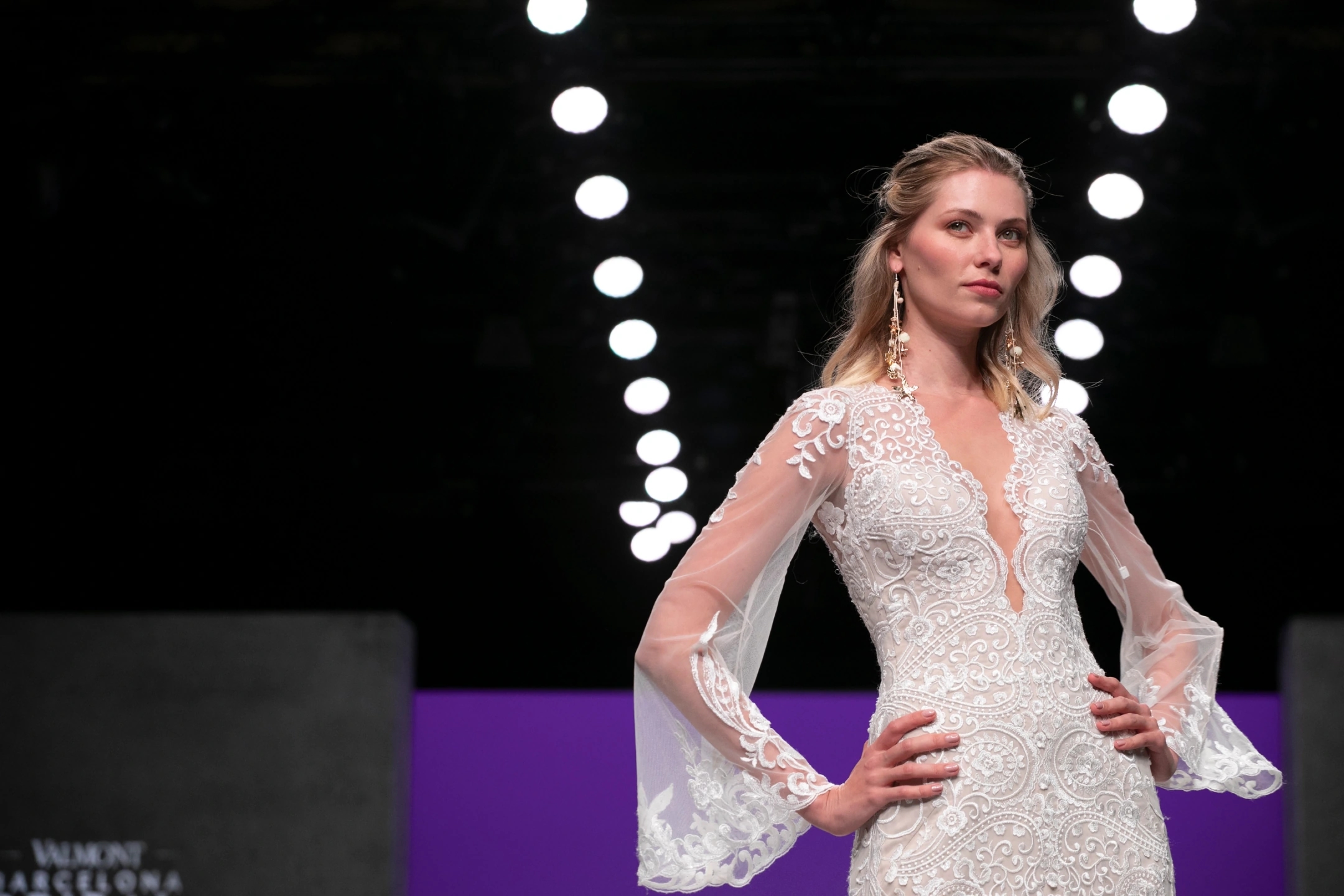 Modelo con vestido de novia en pose de jefa parada de frente en el desfile de María Salas para la Barcelona Bridal Fashion Week.