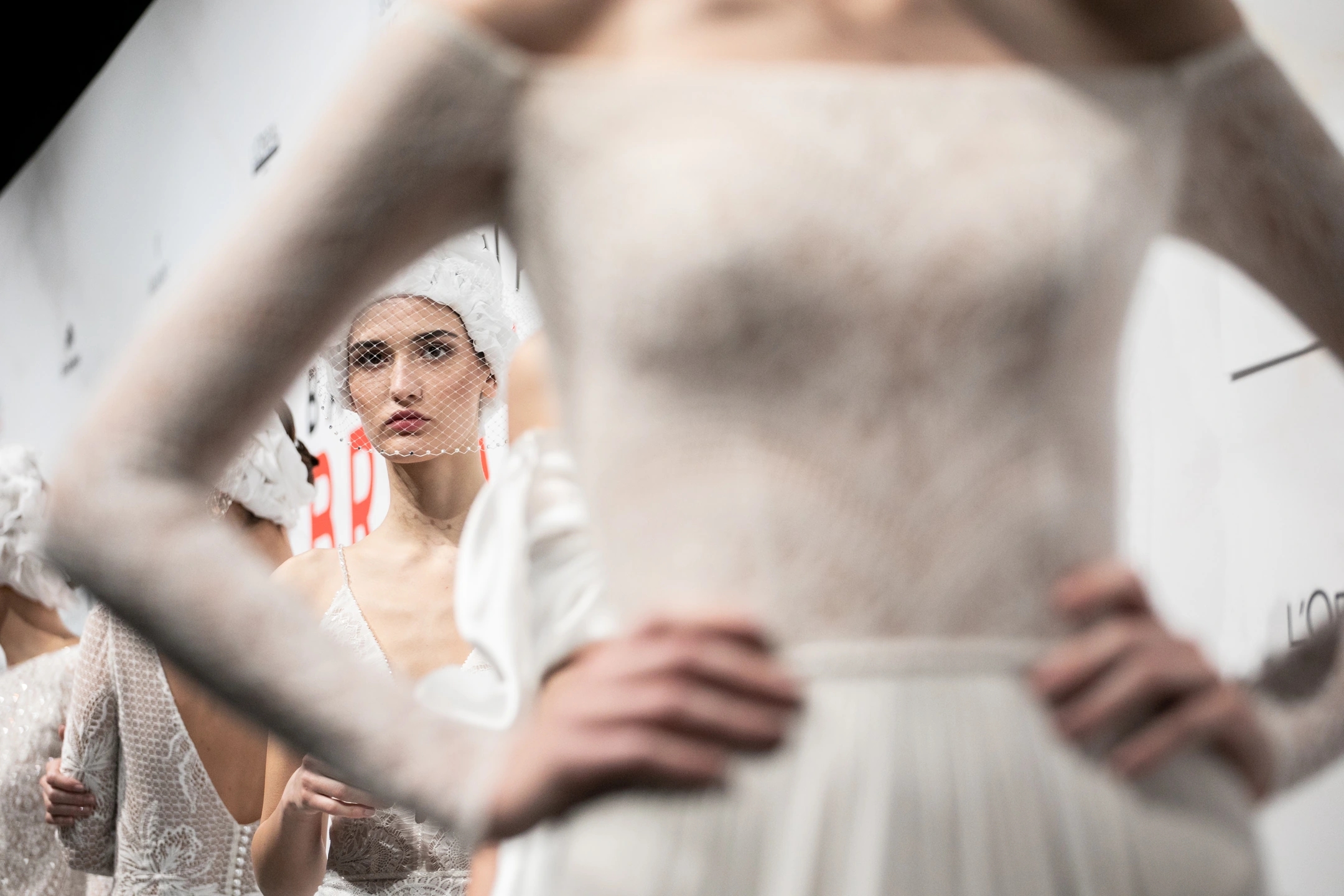 Modelo con vestido de novia de frente en el backstage esperando al desfile de Flora para la Barcelona Bridal Fashion Week.