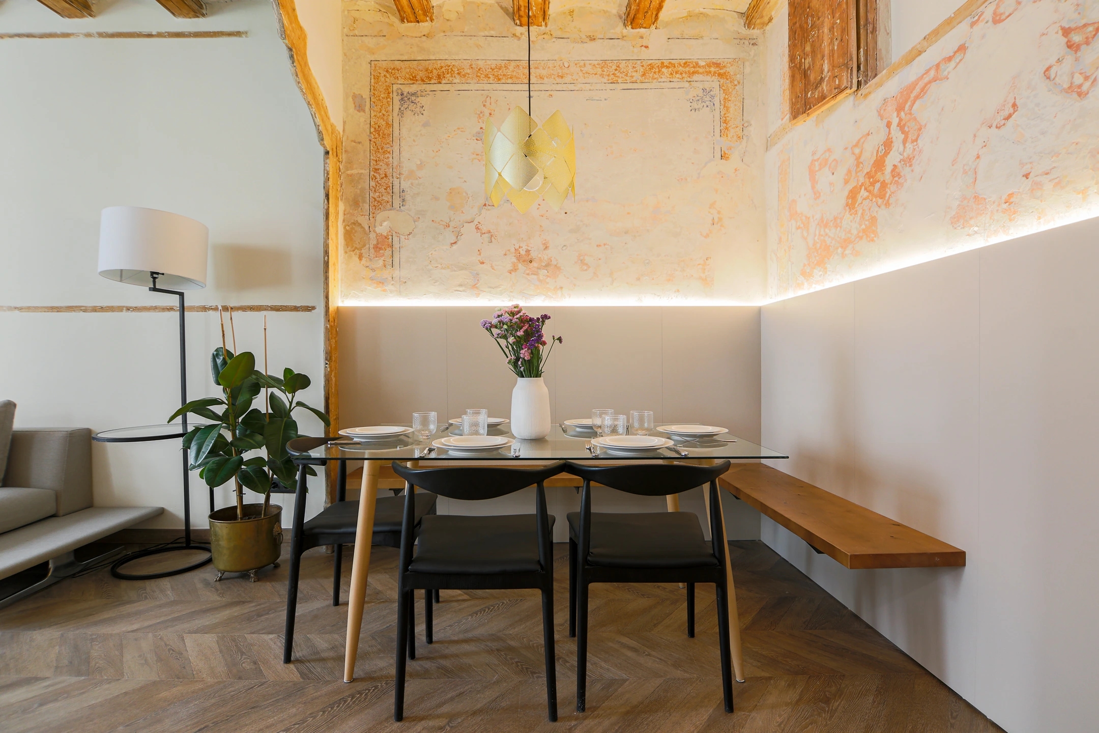 Foto del comedor en calle del Carme de Barcelona. Estilo clásico modernista, con estetica actual. Colores crema suaves y paredes con los mosaicos originales.