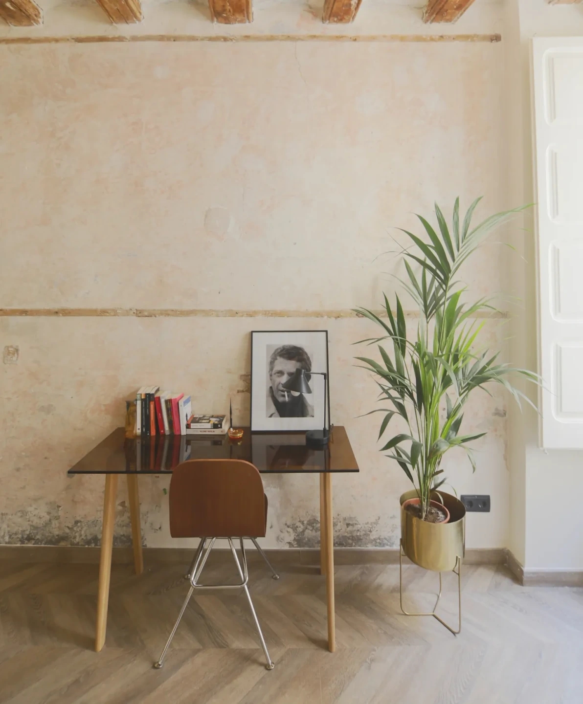 Escritorio en pared con mosaico modernista y vigas de madera. Planta vertical al lado del escritorio.