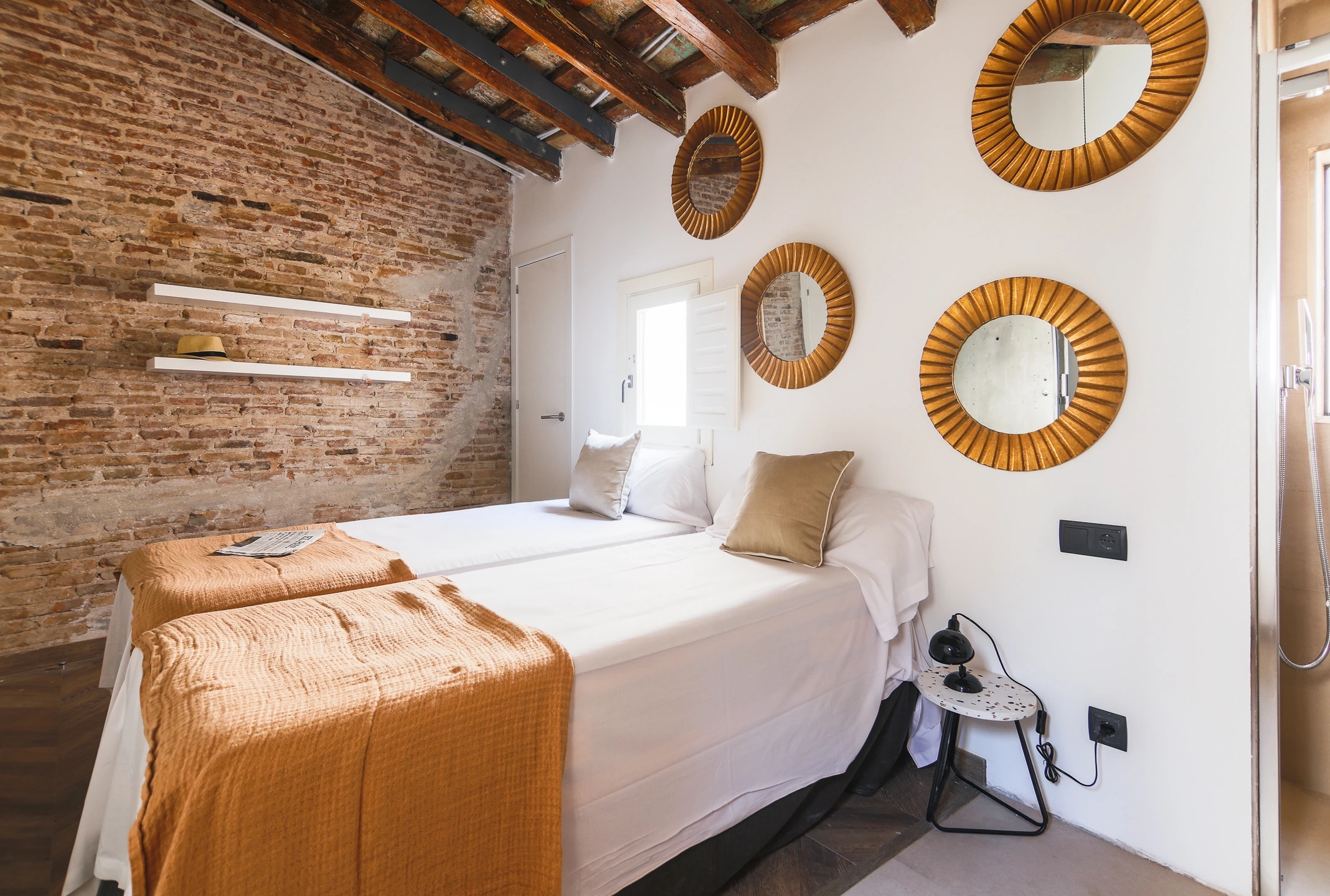 Foto del dormitorio en calle del Carme de Barcelona. Estilo clásico modernista, con estetica actual. Colores marrón suaves y paredes blancas con vigas de madera.
