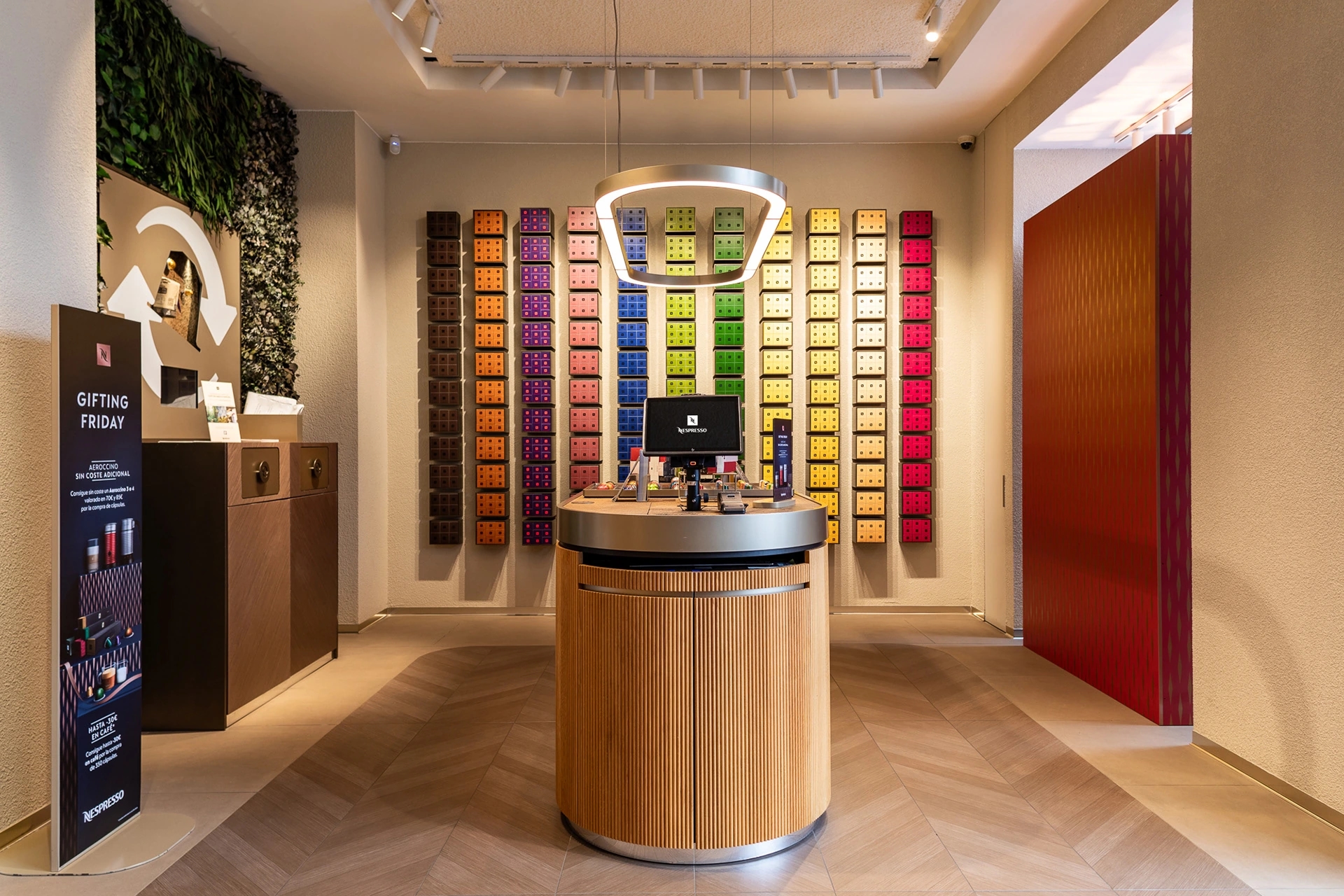 Tienda Nespresso con pared llena de cápsulas de diferentes colores en la tienda Nespresso gran vía de Madrid